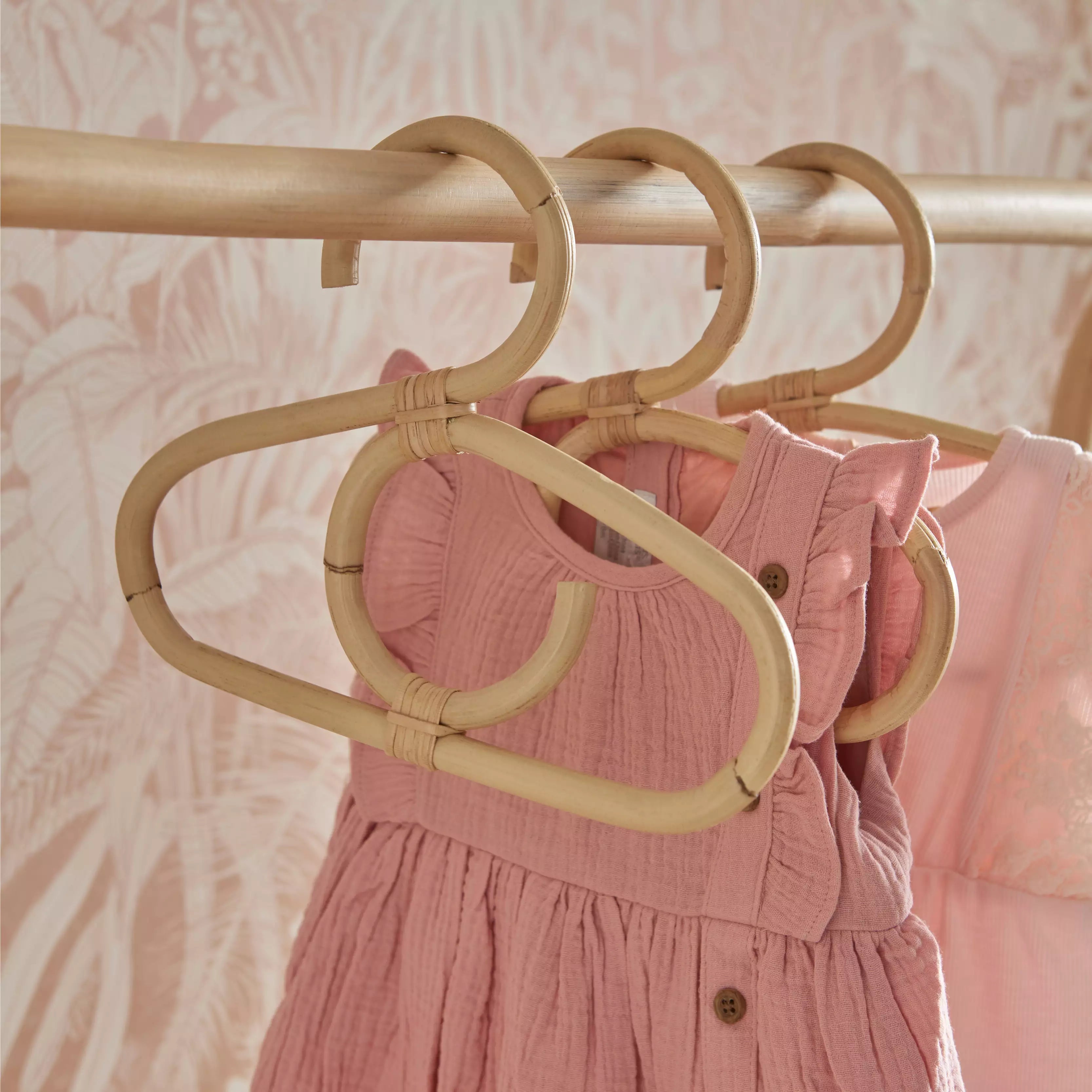 Aria rattan baby hangers hung on a clothes rail CuddleCo