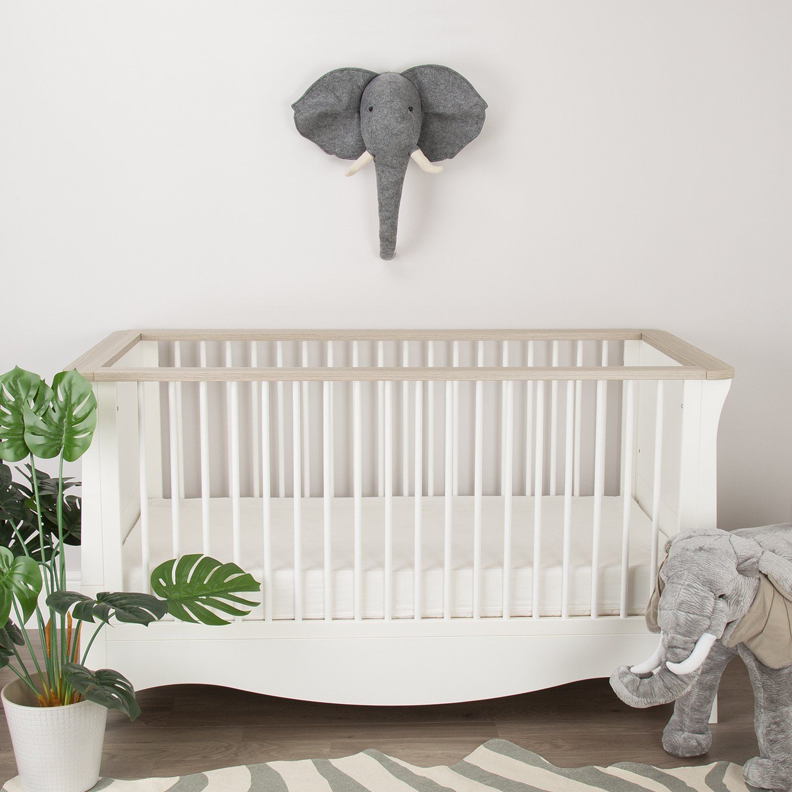Grey Elephant Head Wall Decor above white cot in a Nursery. Wall head mounts by Childhome.