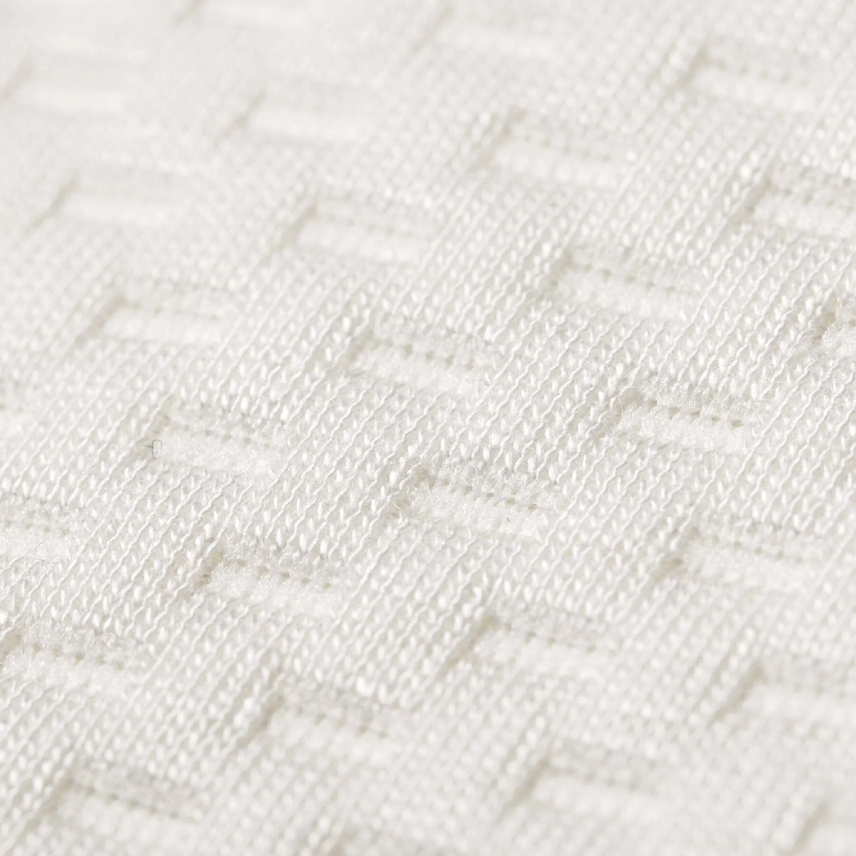 Close-up of a white woven fabric with a textured geometric basketweave pattern.