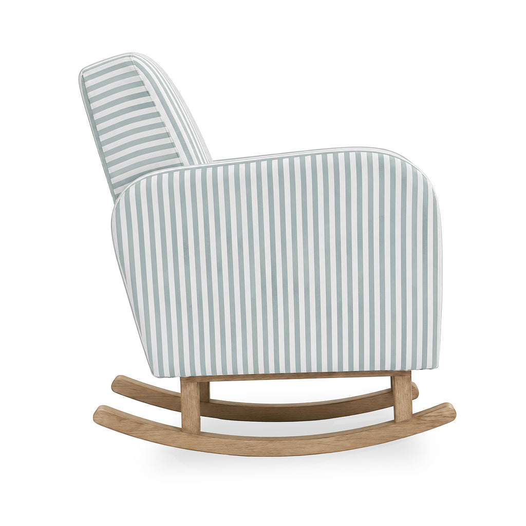 A modern upholstered rocking chair with a light blue and white vertical stripe pattern on the seat and back, supported by a natural oak wood rocking base, shown against a plain white background.