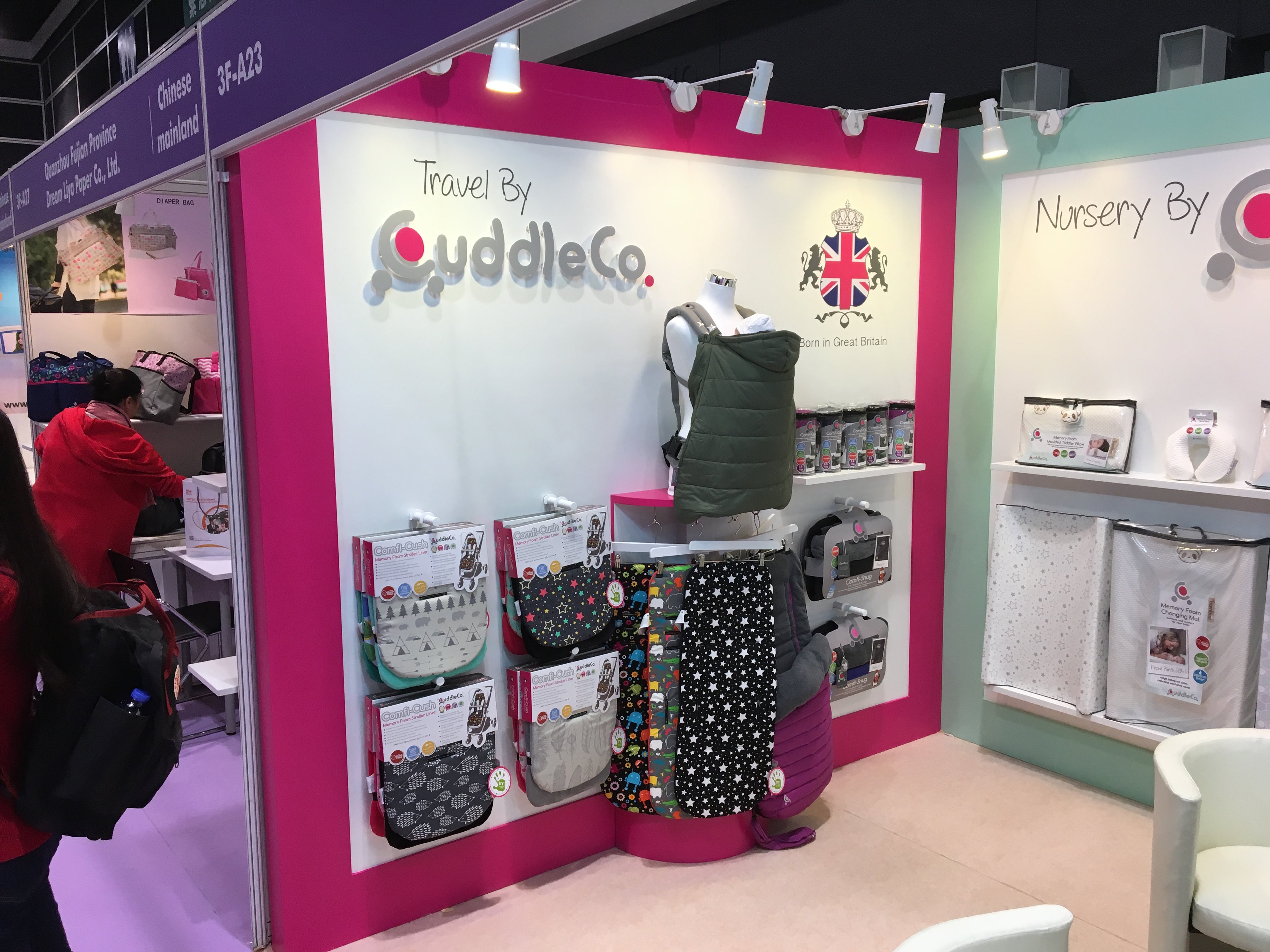 Display of baby products with 'CuddleCo' branding at a trade show booth.