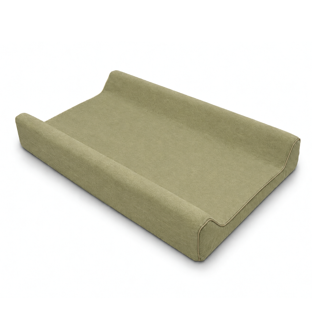 An upholstered changing pad with a solid sage green fabric cover, shown from an elevated angle on a clean white background.